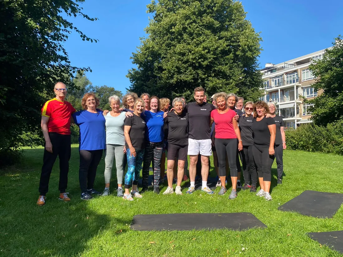 Groep leden met hun trainer in de zon na een buitentraining bij Club Vit, Den Haag