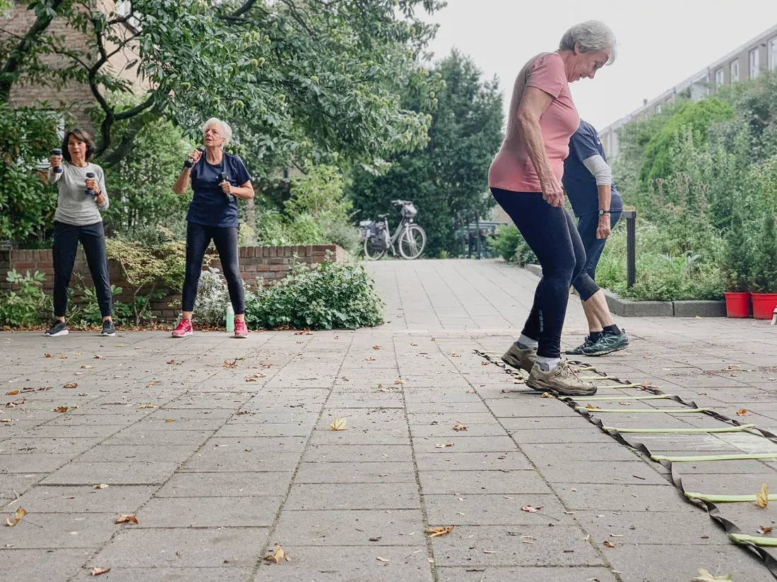 Leden doen buiten een agility-oefening bij Club Vit