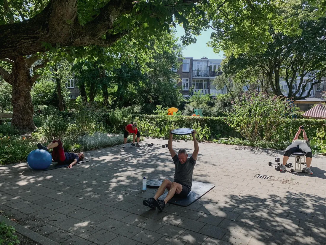 Leden doen circuittraining buiten in het park bij Club Vit, Den Haag
