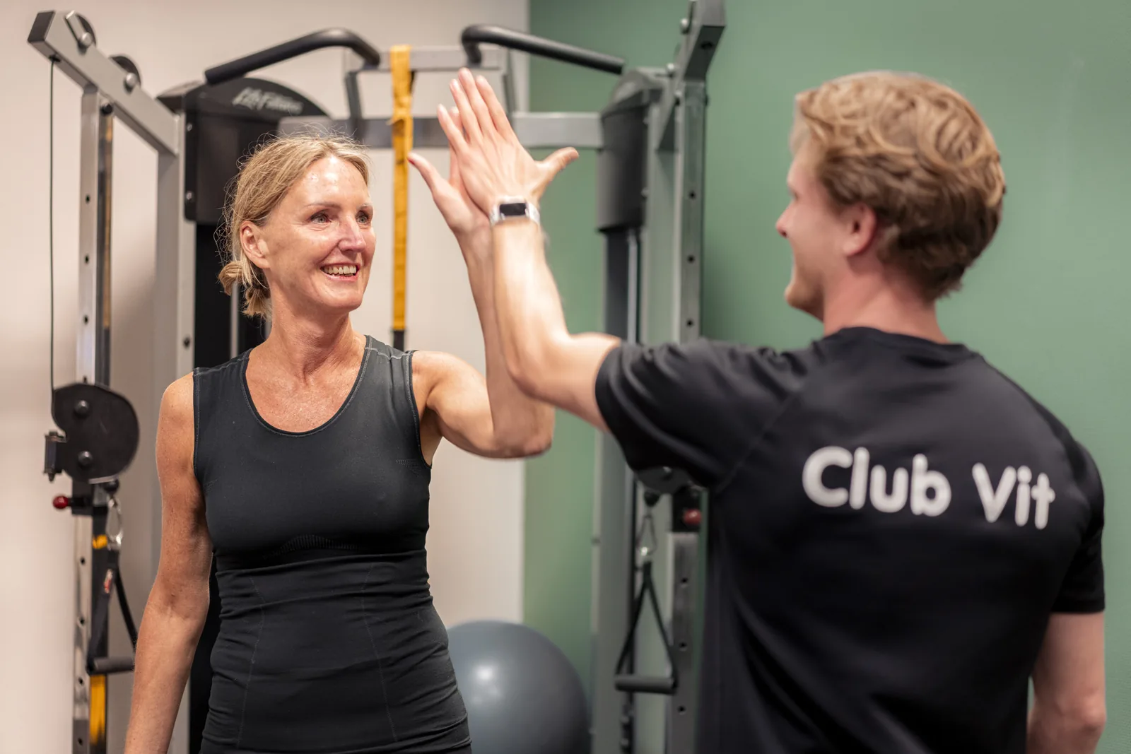 Trainer begeleidt een lid tijdens de training bij Club Vit
