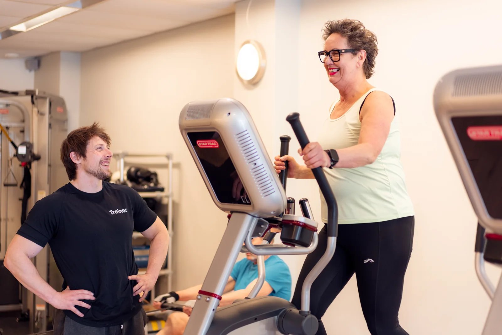 Trainer en lid lachen tijdens de training bij Club Vit
