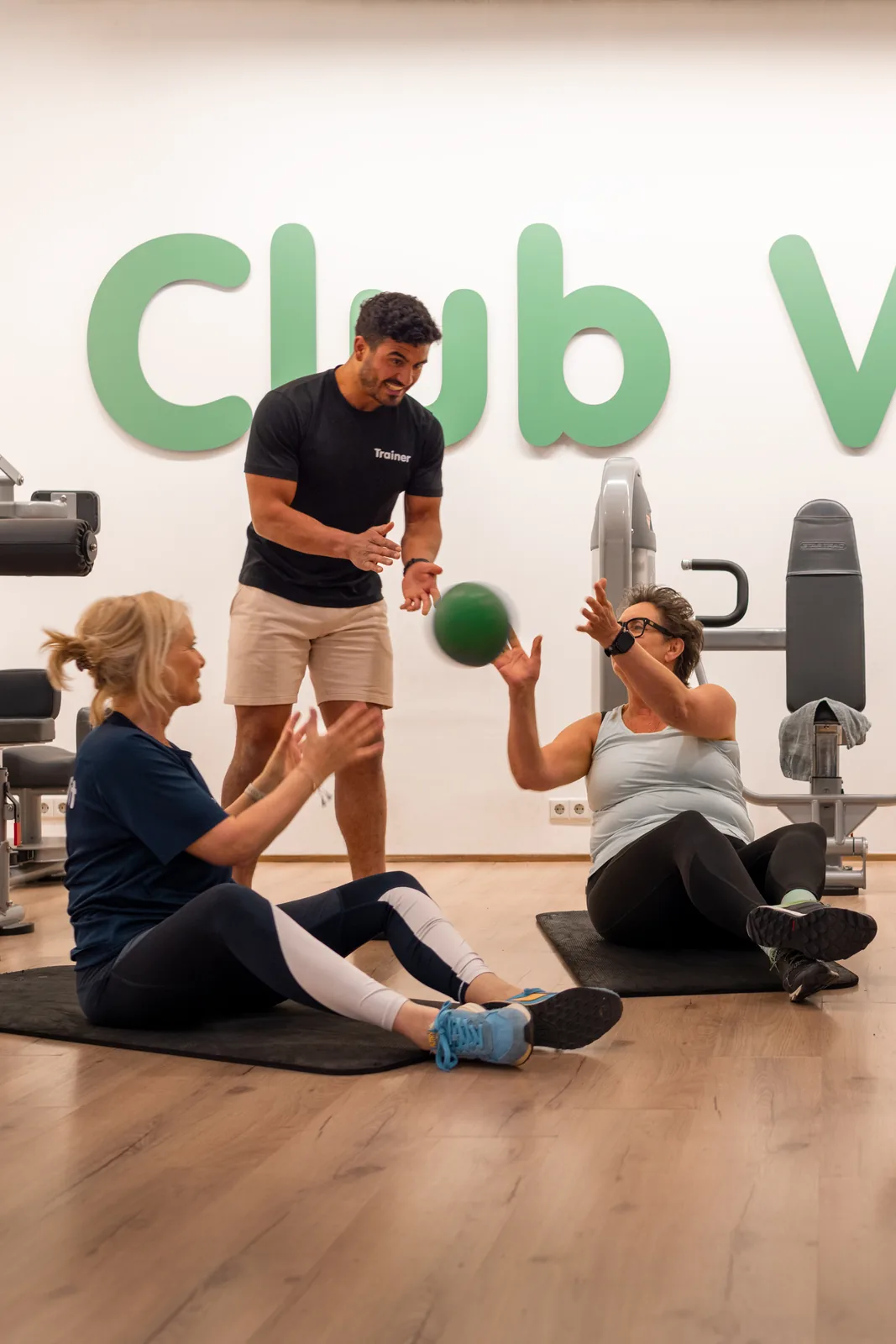 Trainer helpt een lid op een toestel bij Club Vit