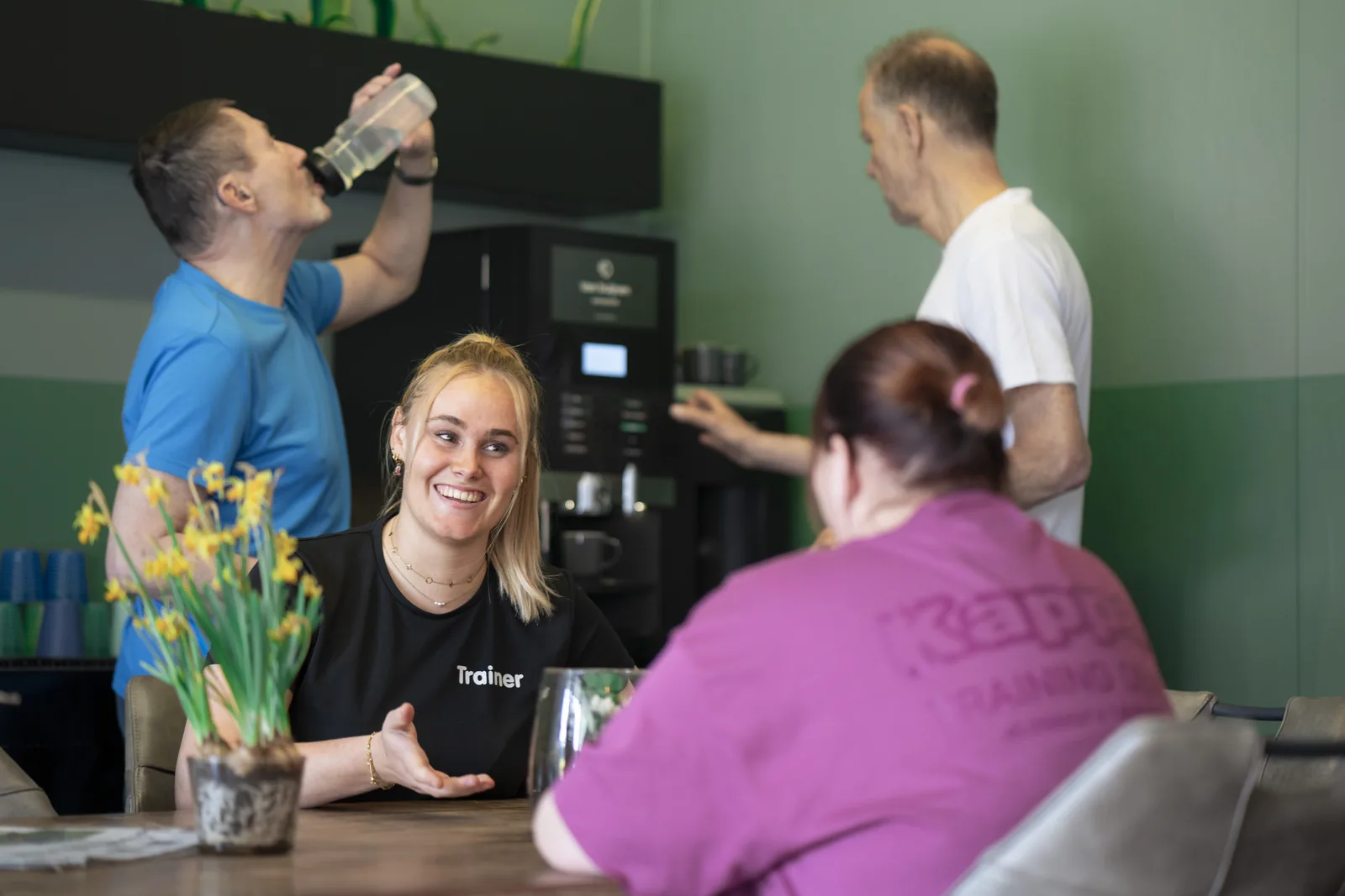 Leden en trainer drinken samen koffie na de training bij Club Vit, Den Haag