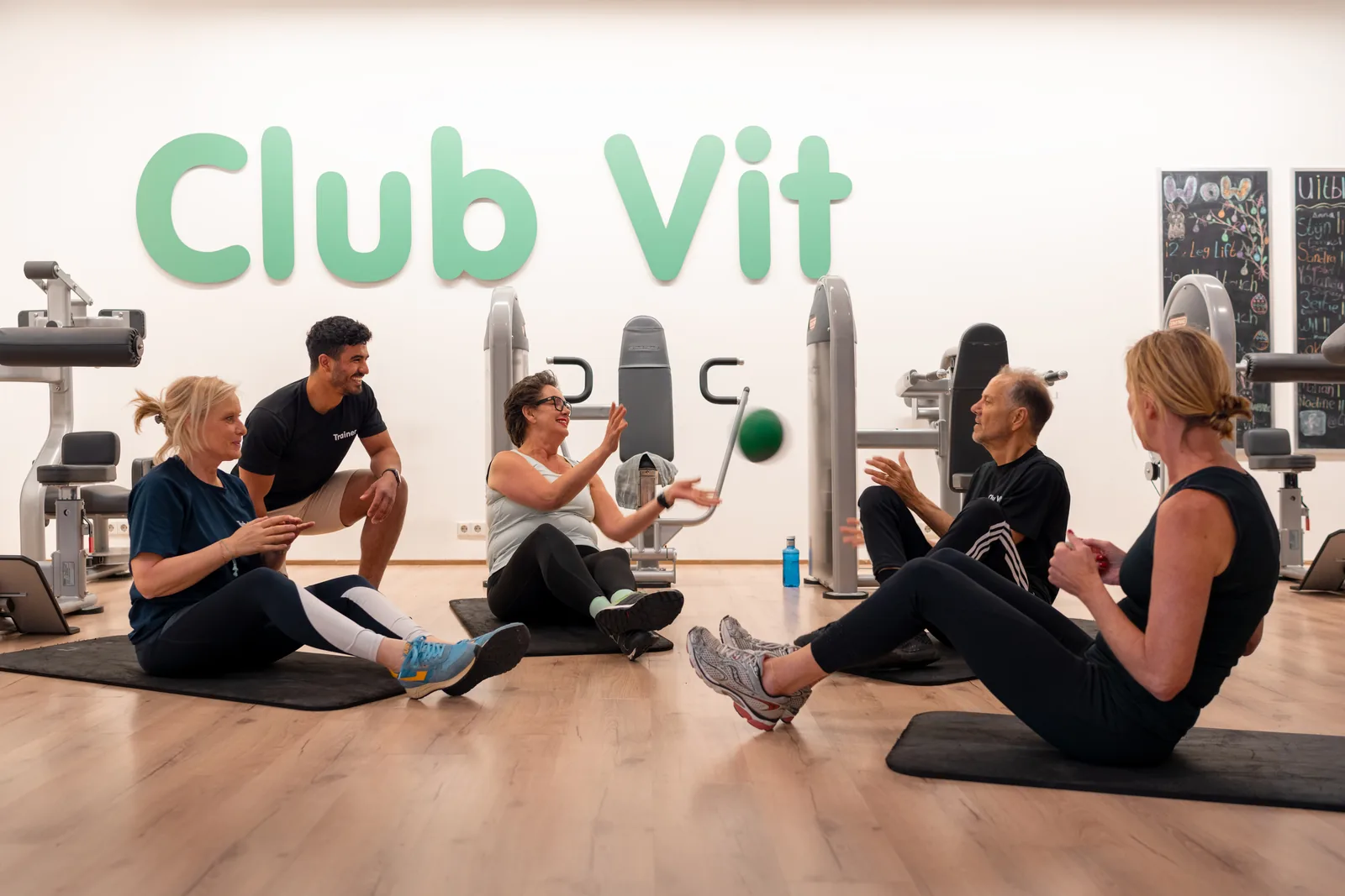 Groepje leden traint samen op matten met hun trainer in de zaal van Club Vit, Den Haag